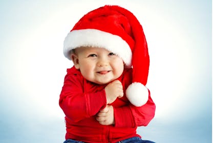 Cheeky smiling baby wearing Santa outfit