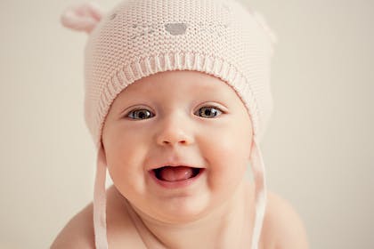 baby wearing hat with ears and face on it