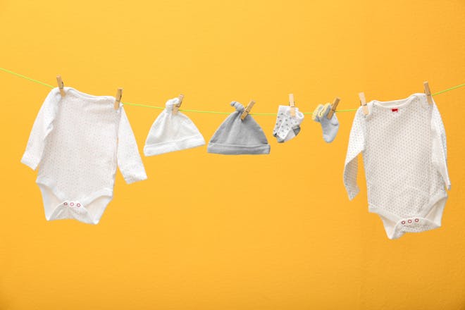 baby clothes on a line on a yellow background