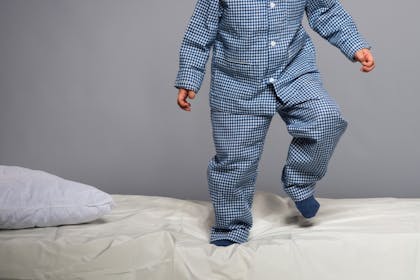 Young child bouncing on a bed