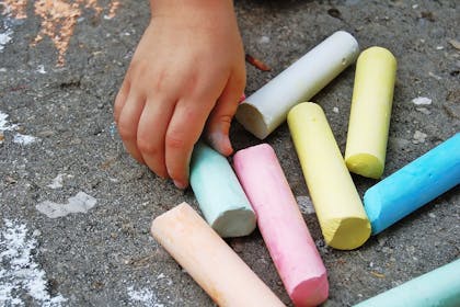 child's hand holding giant outdoor chalk