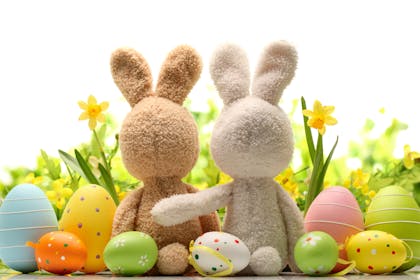 Two toy Easter bunnies with Easter eggs