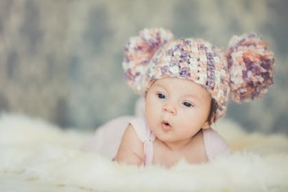 Baby wearing a knitted double pom-pom hat