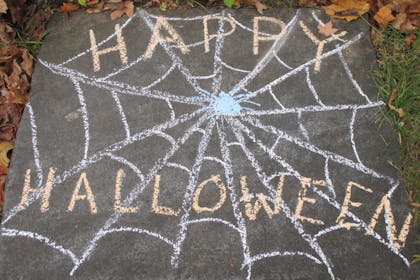 'Happy Halloween' written on the pavement in chalk 