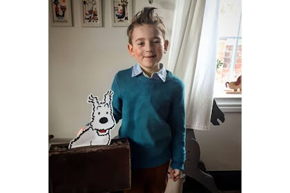 Boy dressed as Tintin with paper cutout Snowy the dog for World Book Day