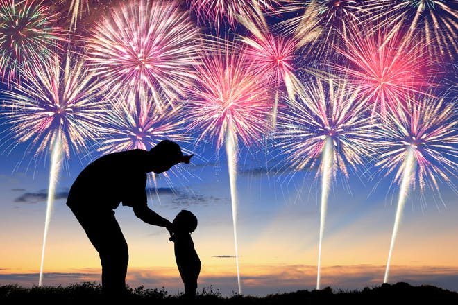 Dad and kid silhouettes at fireworks