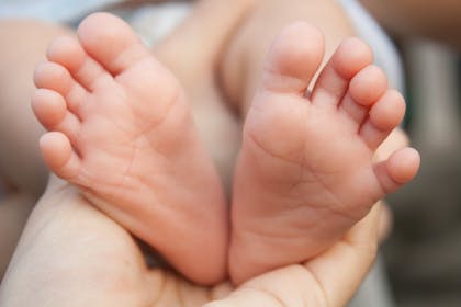 Small feet of newborn baby