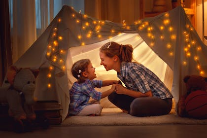 Mum and child in a tent with fairy lights