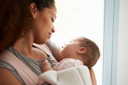 smiling mum and sleeping baby