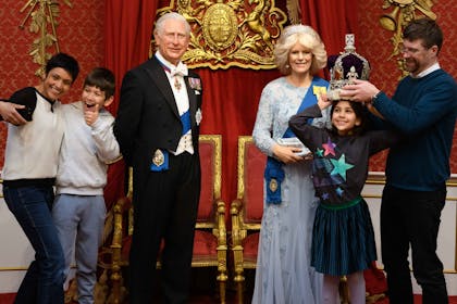 A family enjoy taking photos in with King Charles and Queen Camilla in Madame Tussaud's Royal Palace