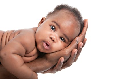 Baby lying in father's hand 