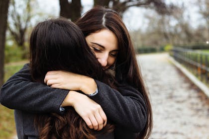 two women hugging in a park