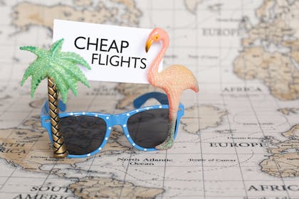 Map with sunglasses and sign saying cheap flights