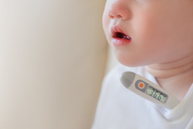 baby with fever thermometer