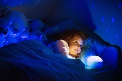 Child in bed with night light