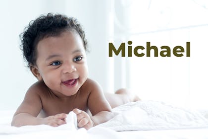 Baby boy pushing himself up on tummy and laughing. Name Michael written in text