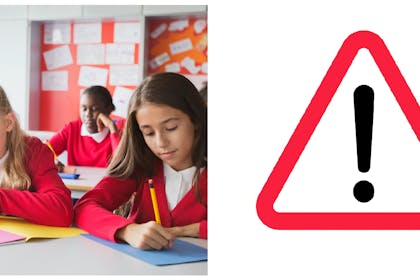Year 6 pupils writing at school | Warning icon