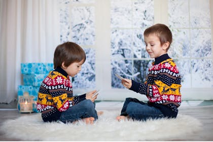 little boys in matching christmas jumpers playing cards