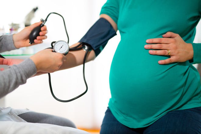 Pregnant woman getting blood pressure check for pre-eclampsia