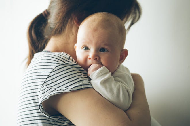 Woman holding baby over her shoulder