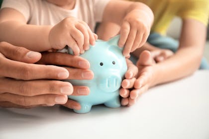 baby holding blue piggy bank