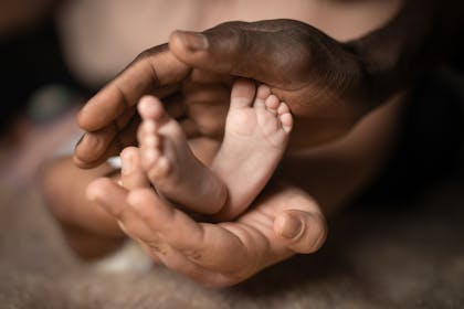 Parent holding baby's feet in their hands