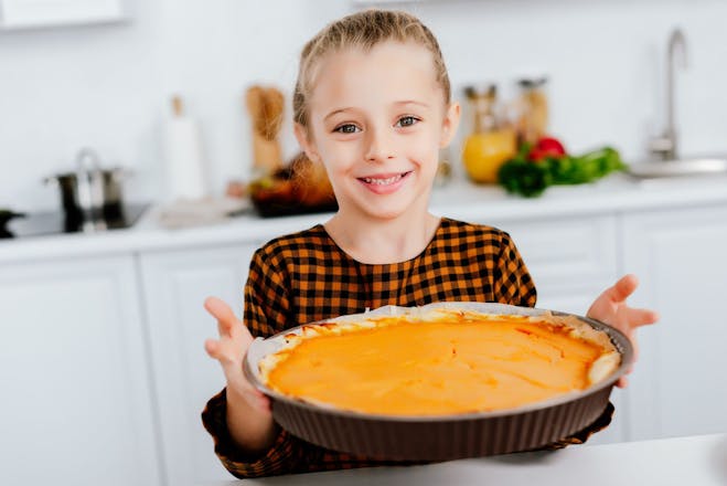 Little girl holds a pumpkin pie