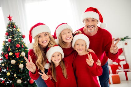 Christmas family portrait wearing red jumpers and Santa hats