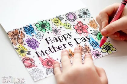 Child colouring in flowers on a printable Mother's Day card