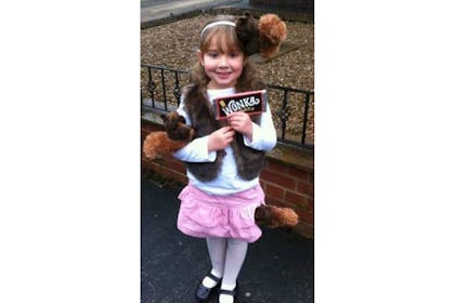 Little girl in a squirrel costume holding a Wonka chocolate bar