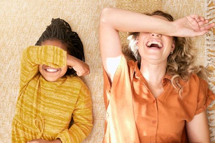 Mother and daughter lying on the floor and laughing