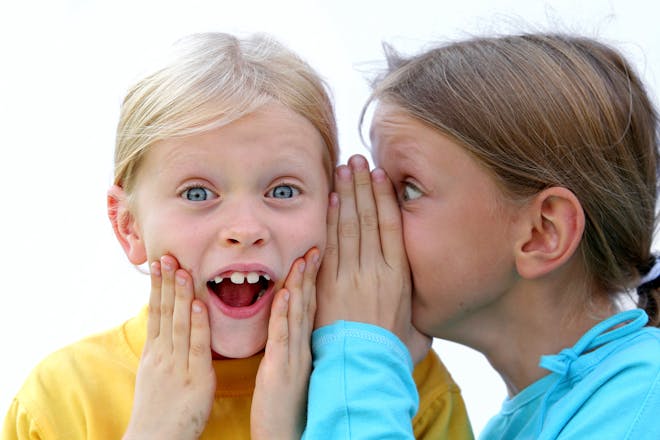 two girls whispering to each other