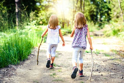 Two girls hiking in sunny forest