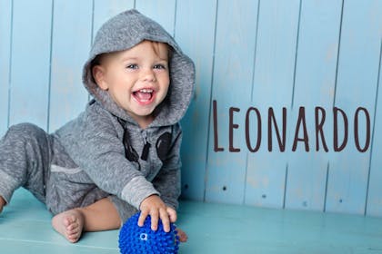 baby with hoodie holding ball