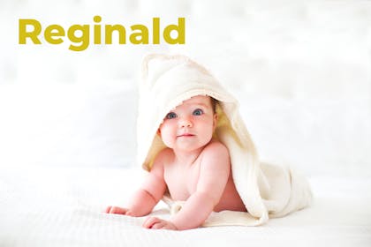 Baby wearing hooded towel. Name Reginald written in text