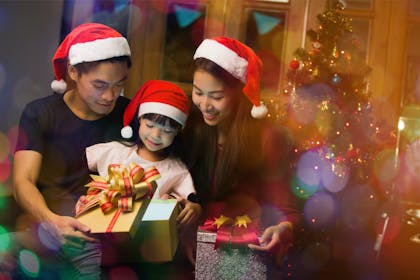 Family of three opening presents at Christmas