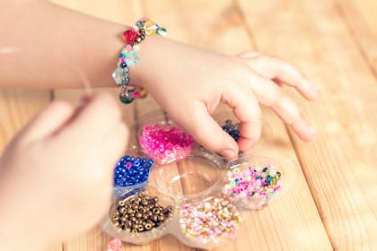 Kid making jewellery with craft kit