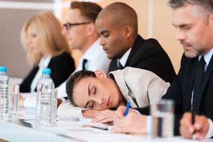Woman sleeping on desk during meeting