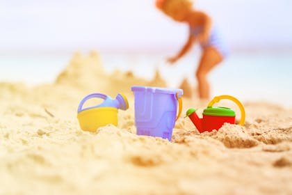 little girl building sandcastles on beach