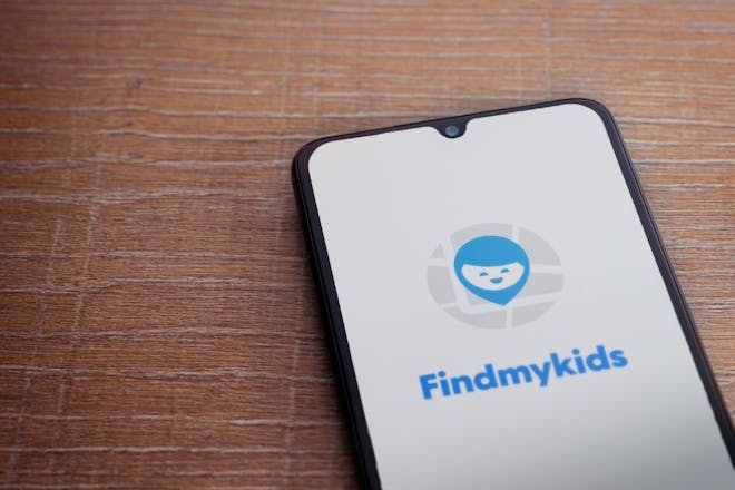 A phone with the Find My Kids app wording on it