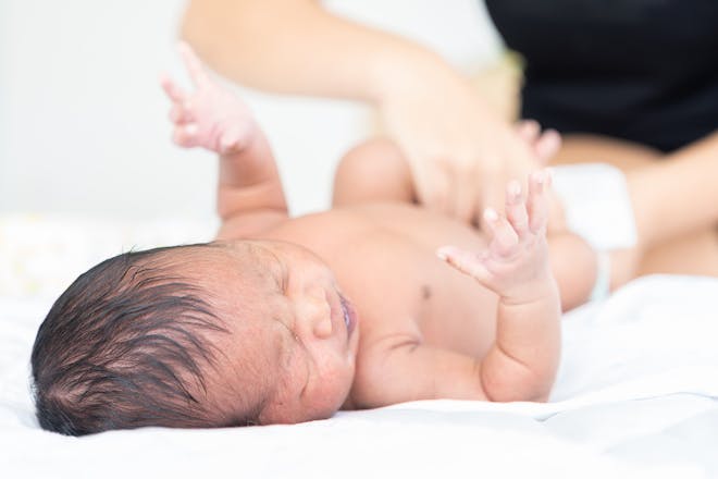 Asian baby getting its nappy changed