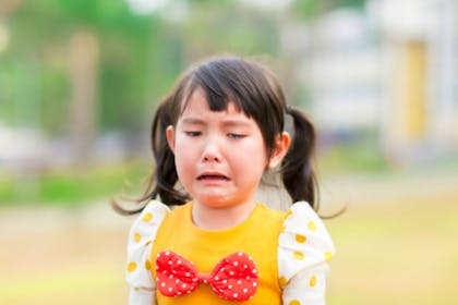 girl in yellow dress crying