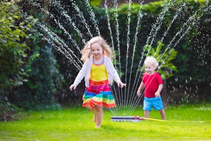 Kids running through sprinkler