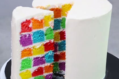 White iced cake that's multi-coloured squares inside
