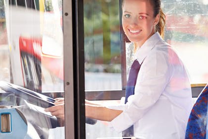 smiling woman driving bus - School minibus driver