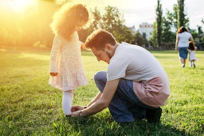 Dad fastening daughter's shoes