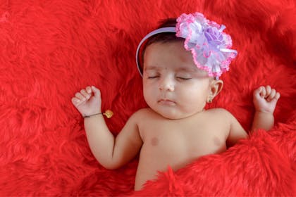 Sleeping Indian baby girl with bracelet and flowered headband