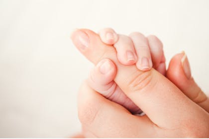 baby holding mum's finger