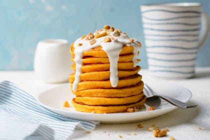 Stacked carrot pancakes with yoghurt and nuts