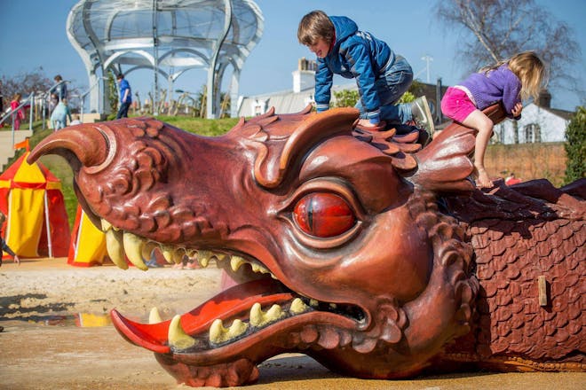 Two children climb on the dragon sculpture at Hampton Court Palace